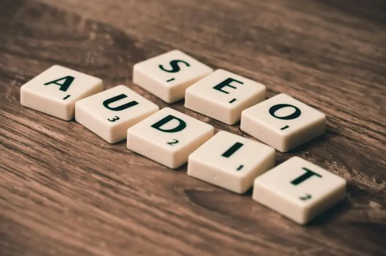 Scrabble tiles spelling SEO Audit on wooden surface, symbolizing digital marketing strategies.